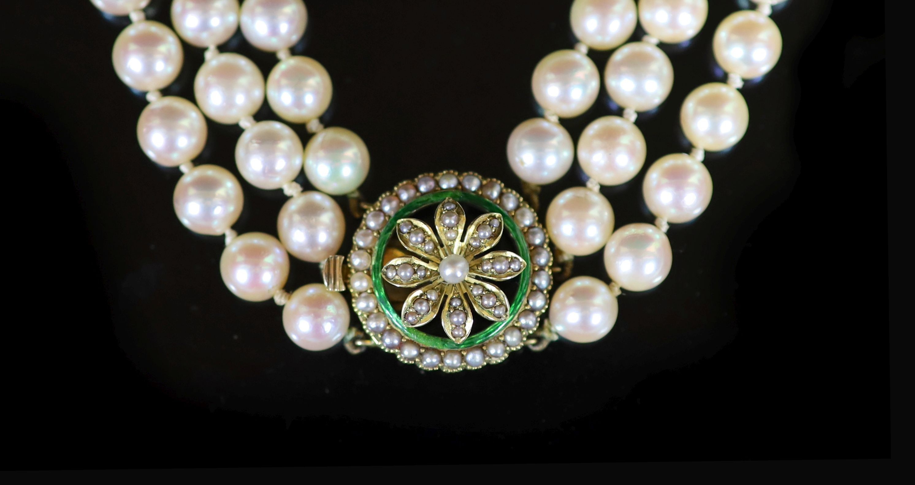 A mid 20th century triple strand cultured pearl choker necklace, with gold, seed pearl and enamel set circular clasp